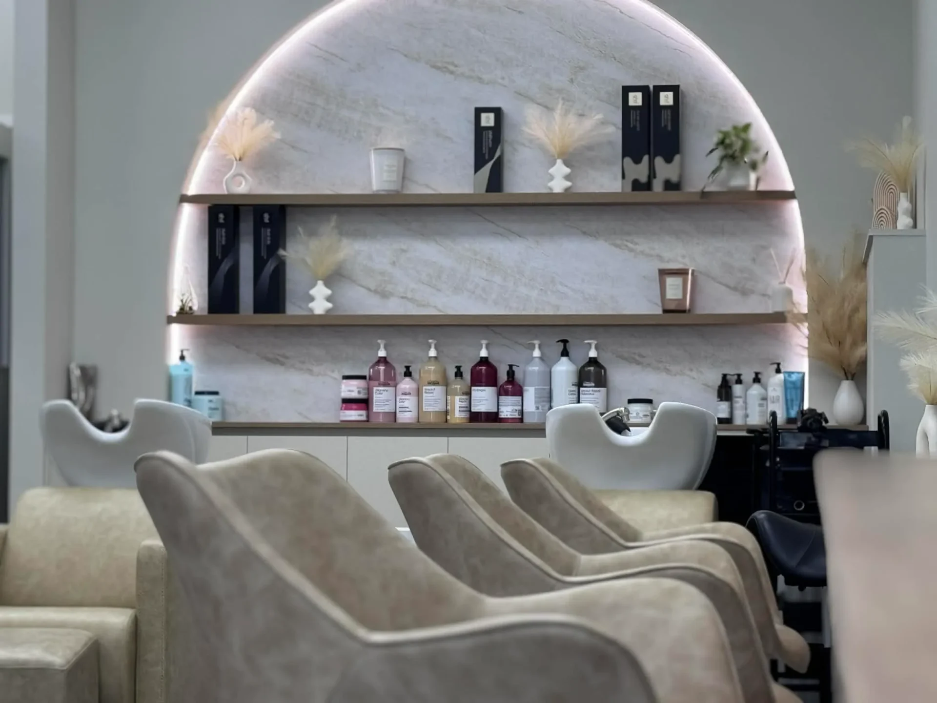 Stylish modern salon interior with chairs and shelves.