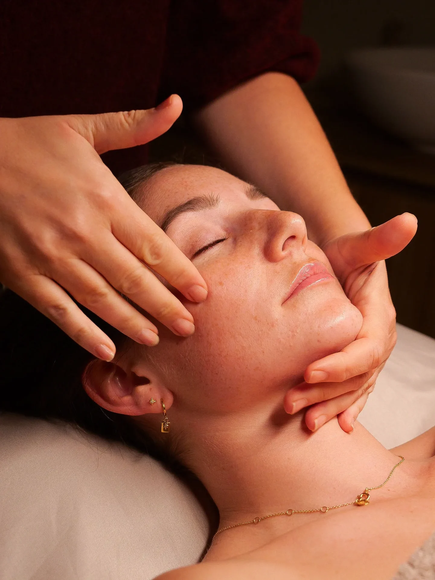Woman receiving facial massage at spa