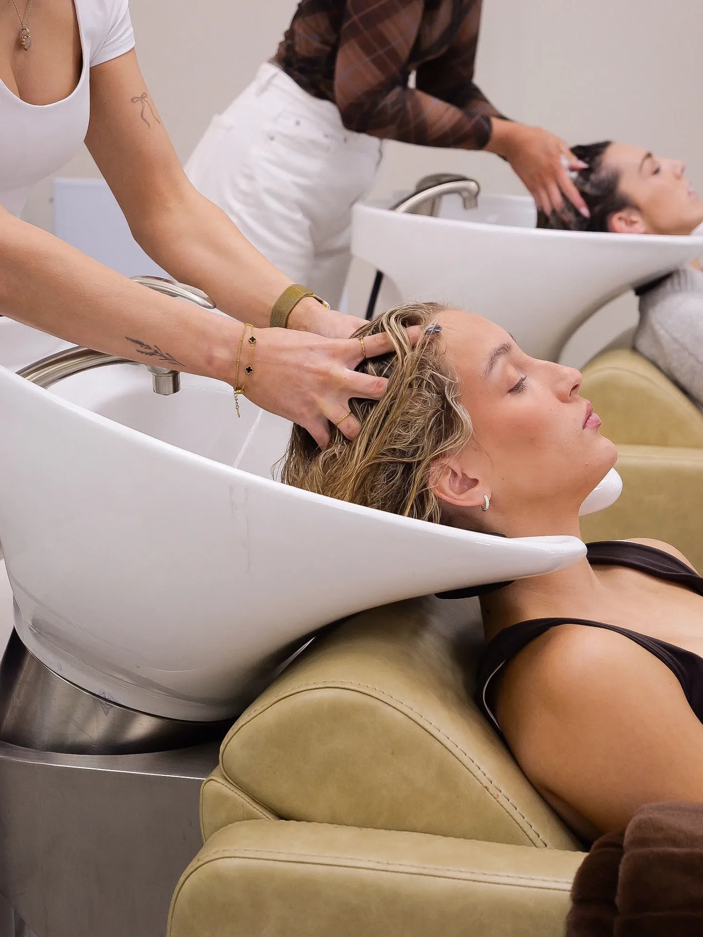 Woman getting hair washed at salon sink