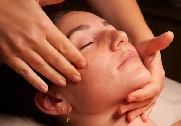 Woman receiving facial massage at spa