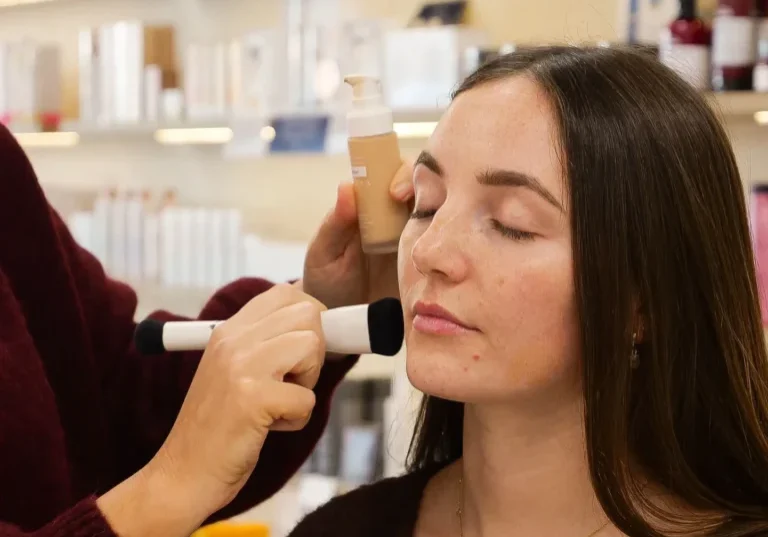Makeup artist applying foundation to woman's face